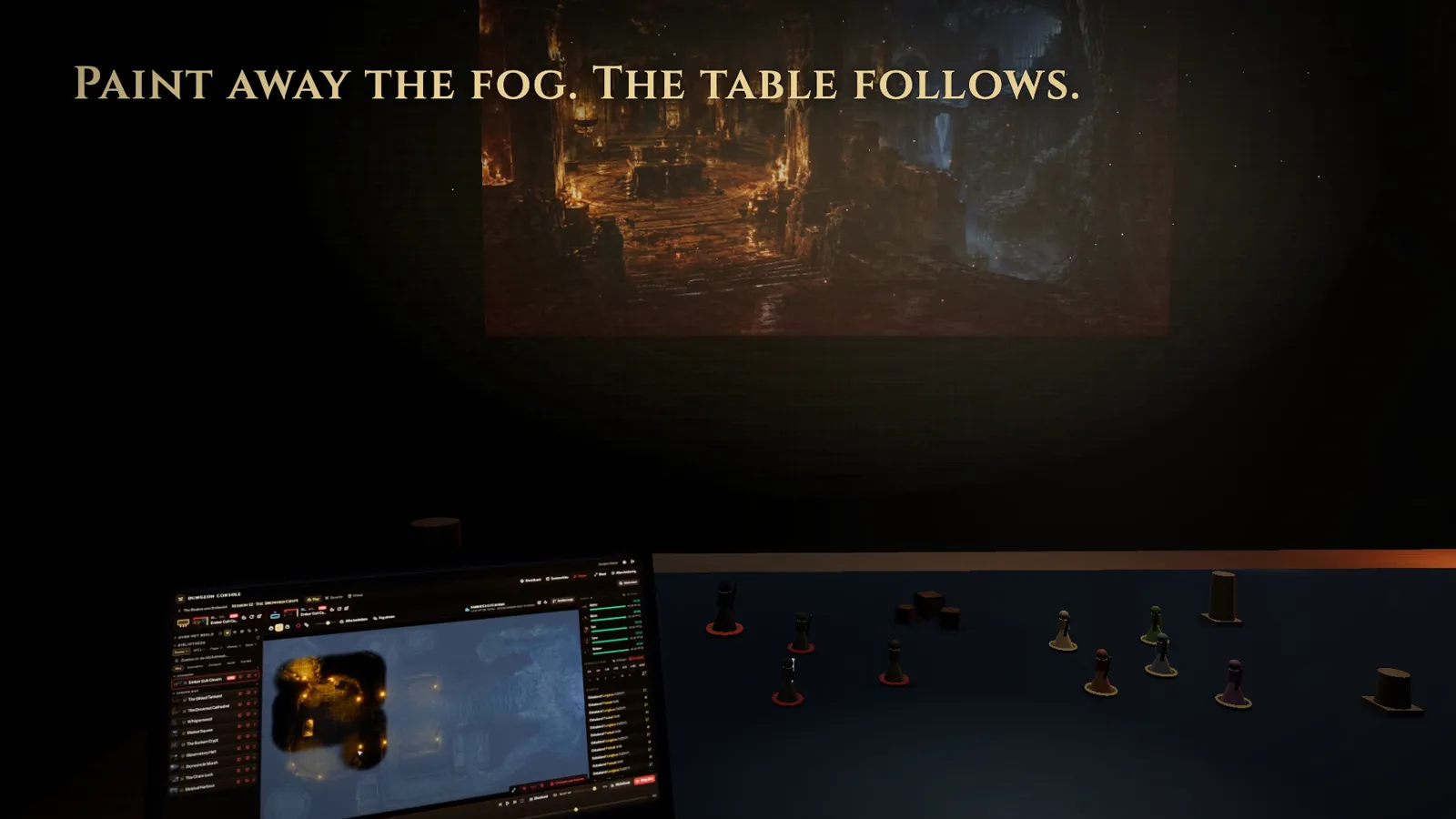 The DM paints away fog on the laptop while the projector reveals the same cavern on the table.